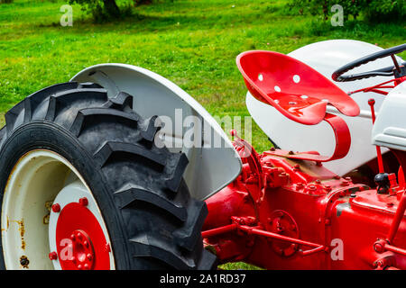 Gray, ME - September 9, 2019: A freshly painted antique red tractor on green grass Stock Photo