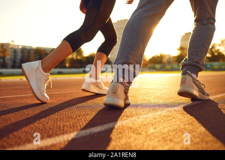 Legs of runners at dawn. Jogging in the stadium. Training athletes. Stock Photo
