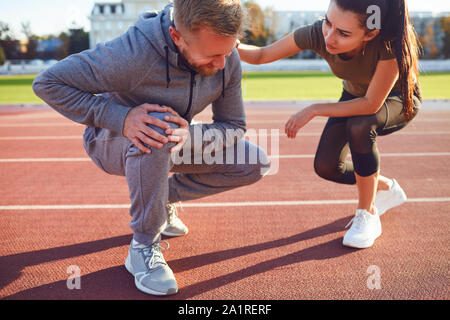 Knee injury in training. A male injured his leg during exercise. Stock Photo