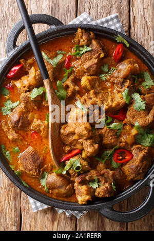 Lamb rogan josh close-up in a pan on the table. Vertical top view from above Stock Photo