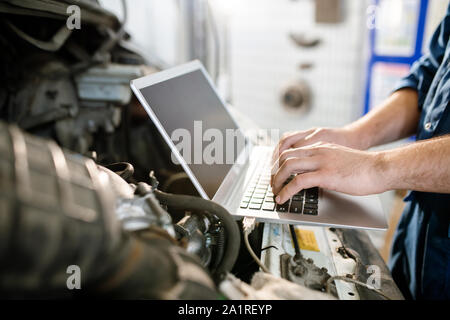 Hands of young contemporary worker of technical service touching keys of laptop keypad while looking for online instructions or data Stock Photo