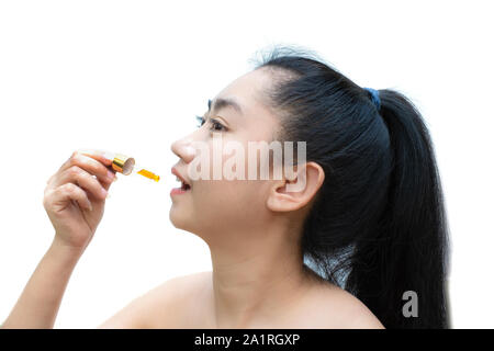 Woman holding a dropper sublingual Cannabis oil at white background Stock Photo