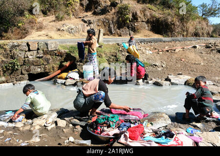 Women and girls wash clothes in a dirty stream. State of Meghalaya, Northeast India, Asia Stock Photo