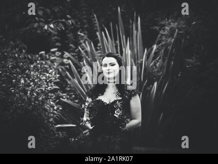 York, UK - 18th August 2019: A bride in a black wedding dress stands alone during an outdoor wedding Stock Photo