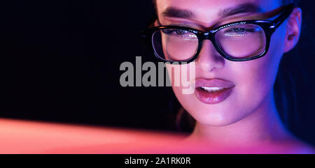 Serious woman working on laptop late at night Stock Photo