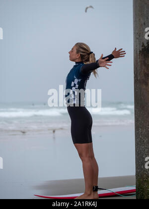 Pro surfer Sage Erricson stretches before the next heat at 2019 US Open of Surfing event Stock Photo
