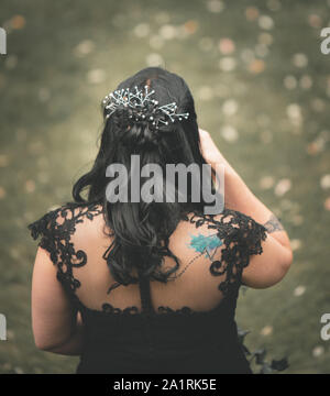 York, UK - 18th August 2019: A bride in a black wedding dress stands alone during an outdoor wedding Stock Photo