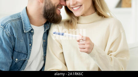 Woman surprising her husband with positive pregnancy test Stock Photo