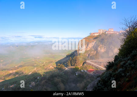 Foggy landscape by Sicilian city Enna in central Sicily, Italy photography in the early summer morning. Moody weather, misty countryside. Fog, mist. City on a high rock. Stock Photo