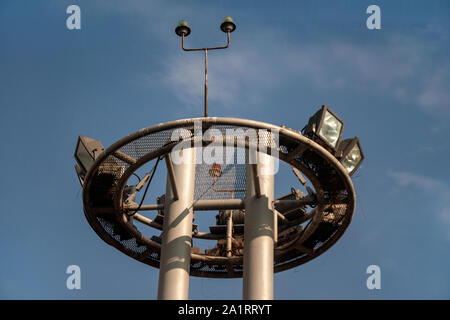 Tower of lighting and equipment at the airport against the blue sky. Engineering systems of the airport and runway