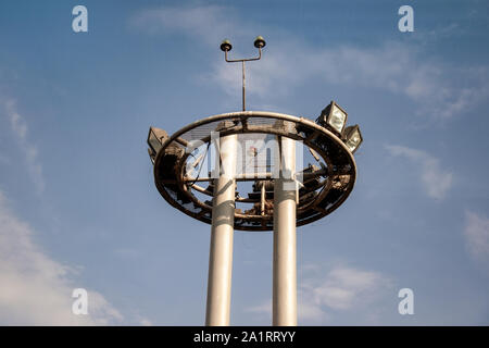 Tower of lighting and equipment at the airport against the blue sky. Engineering systems of the airport and runway