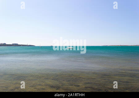 Scenic view on seascape from sea bay. Boats and ships in the distance. Skyline, coast and clear sky in frame. Vacation at the sea background. Stock Photo