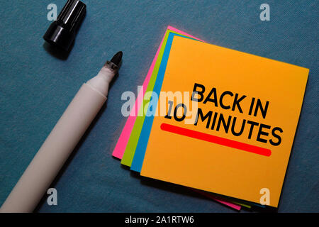 Back in 10 Minutes on sticky notes isolated on Office Desk Stock Photo