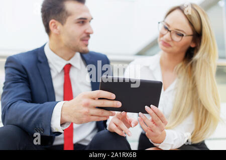 Young businessman proving financial strategy to businesswoman indoors Stock Photo