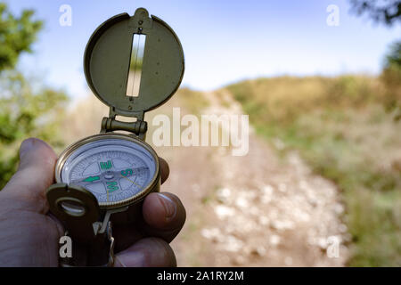 Man with a compass in his hand on the trail Stock Photo