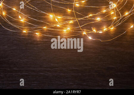 Christmas lights frame decoration on dark wood with copy space. Merry Christmas and New Year holiday background. Stock Photo