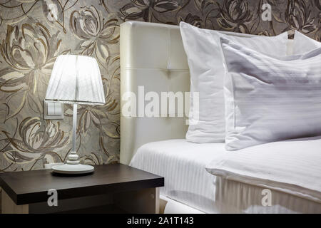 night lamp with lampshade on bedside tables near Double bed with pillows in interior of the modern bedroom Stock Photo