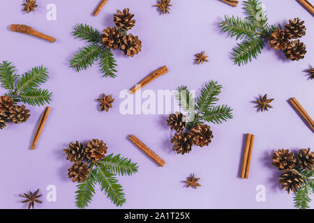Christmas or winter composition. Frame made of fir tree branches, pine and cinnamon on pastel purple background. Christmas, winter, new year concept. Stock Photo