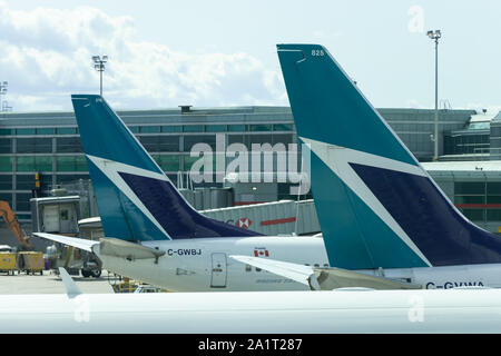 Two WestJet Airlines tail fin logos parked at their gates at Toronto Pearson Intl. Airport. Stock Photo