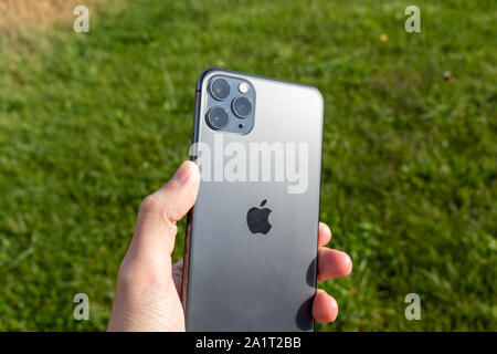 Man holding an iPhone 11 Pro Max on a sunny day. Stock Photo
