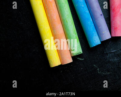 row of colored chalk On the blackboard. Stock Photo