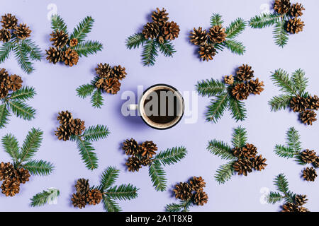 Winter composition. Frame made of fir tree branches, pine and cup coffee on pastel violet background. Christmas, winter, new year concept. Flat lay, t Stock Photo