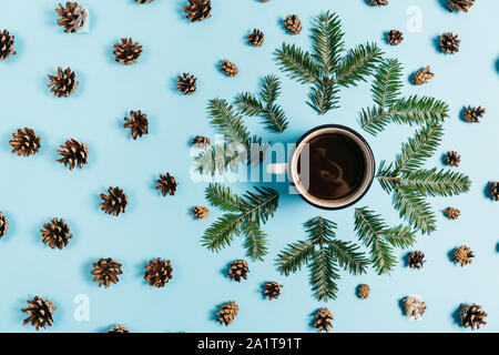 Christmas or winter composition. Frame made of fir tree branches, cup coffee, pine on pastel blue background. Christmas, winter, new year concept. Fla Stock Photo