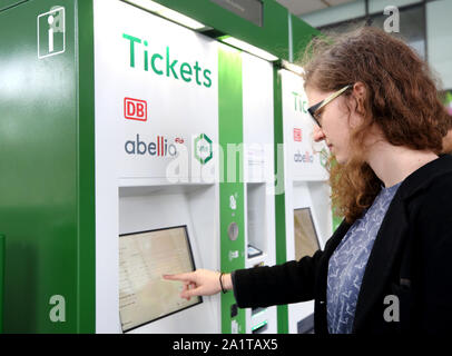 Gelsenkirchen, Germany. 27th Sep, 2019. A train passenger buys a ticket at a new VRR ticket vending machine. From mid-December 2019, the railway will no longer sell VRR tickets at stations in the VRR region. The transport association has commissioned a new service provider to take over the sale. The ticket vending machines are no longer rail red, but VRR green. Credit: Roland Weihrauch/dpa/Alamy Live News Stock Photo