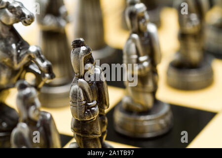 close up of a silver chess pieces on a checkerboard Stock Photo
