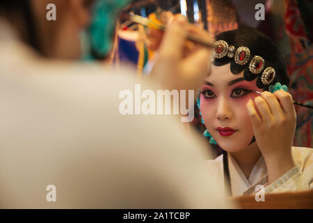 Female Peking Opera actor backstage makeup Stock Photo