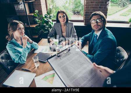 Three person in trendy stylish style formal wear sit on chair in Stock Photo