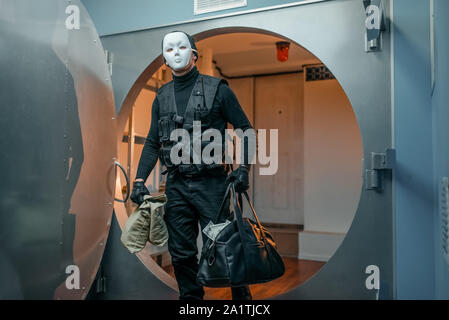 Bank robbery, robber in black uniform and mask Stock Photo