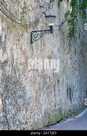 Street lamp on ancient wall in Brasov, Romania, aged fortress brick wall Stock Photo