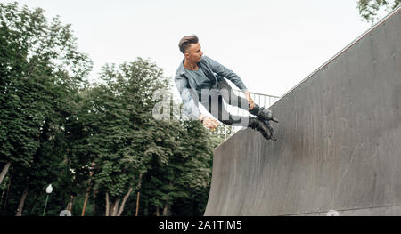 Roller skating, young skater rolling off the ramp Stock Photo