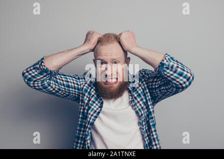 Portrait photo of scared man hold hands on head make scared face worried about situation look at camera stand isolated on light gray background Stock Photo