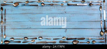Vintage cutlery - spoons, forks and knives on an old wooden background. Selective focus. Stock Photo