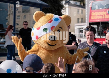 Head Portrait of Pudsey Bear, BBC Children in Need's mascot on esplanade in Llandudno entertaining group of kids Stock Photo