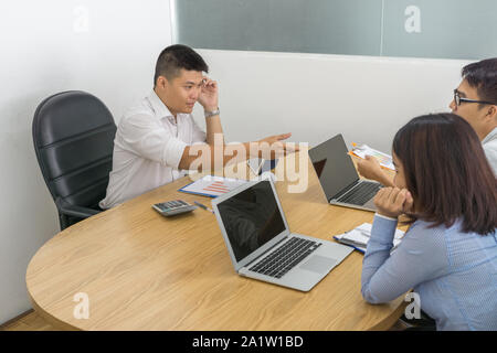 Asian businessman having meeting with his business partners at workplace Stock Photo