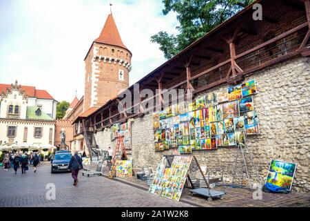Outdoor hanging paintings gallery selling for tourists at St. Florian's Gate, a famous tourists attraction in Krakow, Poland Stock Photo