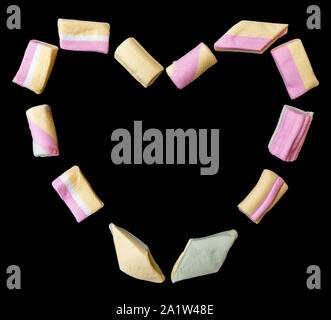 Beautiful heart design made with marshmallows of various colors and shapes on a black background Stock Photo