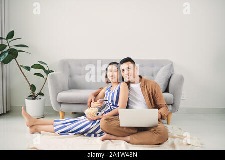 Young Asian couple shopping online at laptop computer at home Stock Photo
