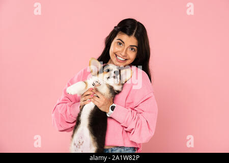 Smiling Girl Holding Welsh Corgi Puppies Isolated On Pink Stock