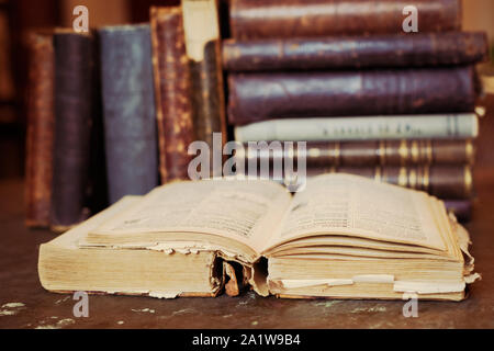 Books shelf with old open book. Old leather bound vintage books Stock Photo