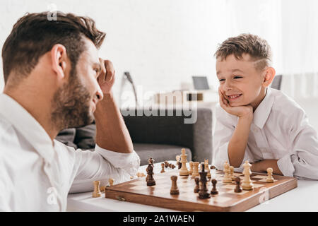 dad and son playing chess together at home Stock Photo