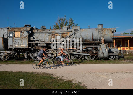 Tourists cycling past an old railway engine at Haapsalu railway station in Haapsalu, Estonia, Baltic states, Europe Stock Photo