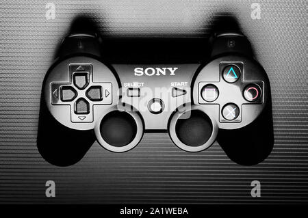 DualShock 3 wireless controller, a gamepad for the PlayStation 3, a home video game console produced by Sony Computer Entertainment, on dark backgroun Stock Photo
