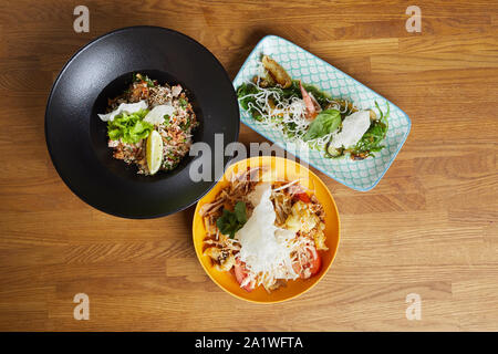 Top view background of three Asian dishes set on wooden table in cafe or restaurant, copy space Stock Photo