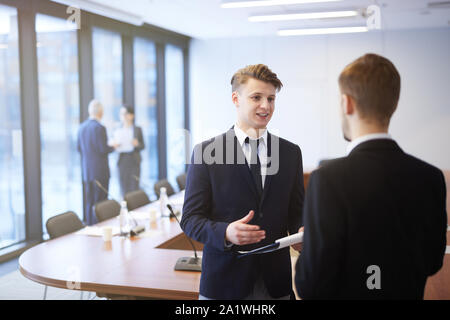 Waist up portrait of two young entrepreneurs discussing projects during break at business conference, copy space Stock Photo