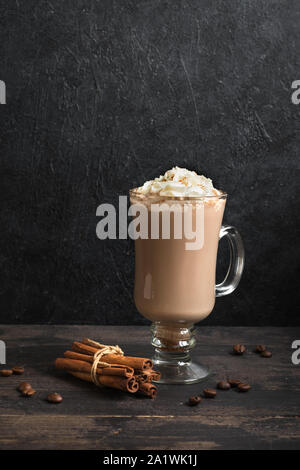 Irish Coffee with whipped cream on black wooden background, copy space. Stock Photo