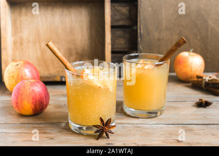 Spicy Apple Cider Drink. Seasonal autumnal homemade apple cider on wooden table. Stock Photo